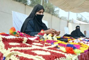 Women are displaying different wool items during the Paralympics Sports Festival to mark the International Day of Persons with Disabilities organized by the Society for Special Persons at Sports Ground.