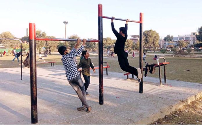 Youngsters playing at outdoor gym stock