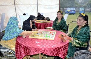Women are displaying different wool items during the Paralympics Sports Festival to mark the International Day of Persons with Disabilities organized by the Society for Special Persons at Sports Ground.