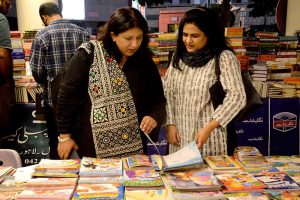 Female visitors browse books at a stall during the 17th International Alami Urdu Conference at the Arts Council of Pakistan
