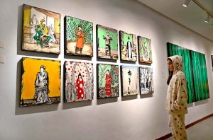 Visitor keenly viewing paintings by artist Nazia Ejaz during an exhibition at Tanzara Gallery