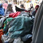 Women busy in selecting and purchasing second hand warm clothes at weekly Sunday Bazaar, Aabpara