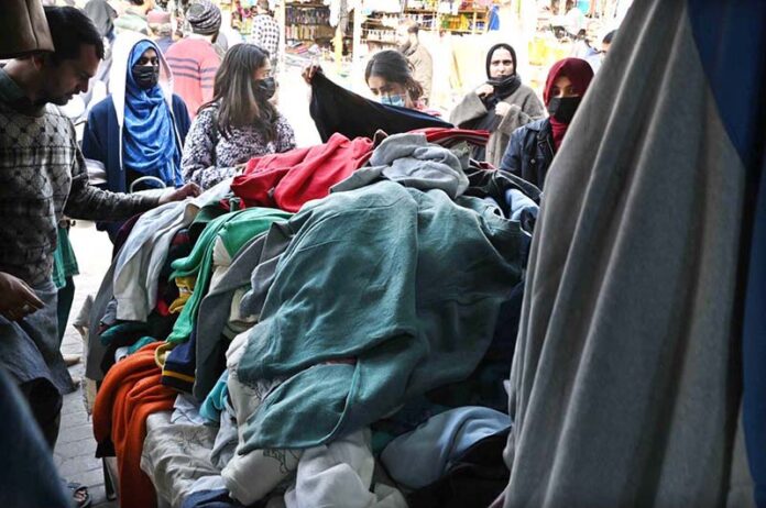 Women busy in selecting and purchasing second hand warm clothes at weekly Sunday Bazaar, Aabpara