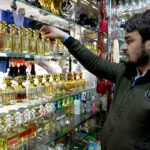 A shopkeeper arranging and displaying perfumes to attract the customers at his shop in the Aabpara Federal Capital