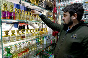 A shopkeeper arranging and displaying perfumes to attract the customers at his shop in the Aabpara Federal Capital