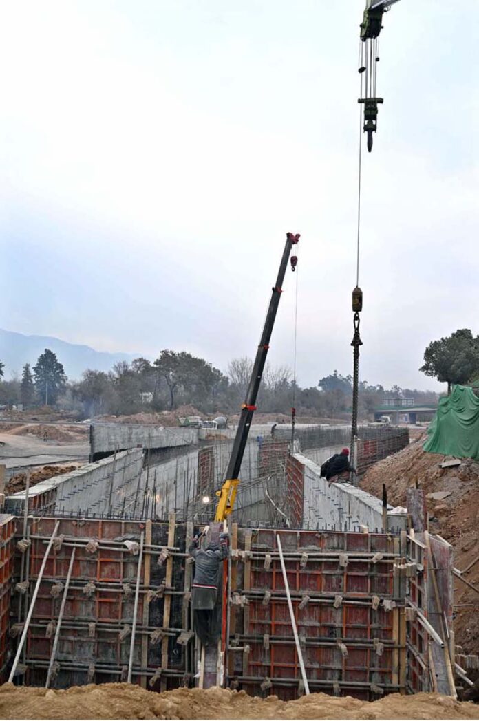 Labourers busy in construction work of Serena Chowk Interchange Project during development work in the Federal Capital