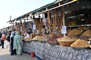 People busy purchasing dry fruits from vendor at H-9 weekly bazaar in the Federal Capital.