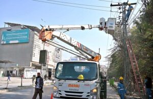 WAPDA staffers busy rectifying fault in electric wires on an electric pole near Commercial Market.