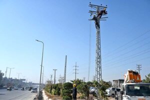 IESCO workers are busy installing electricity wires on an electric pole near IJP Road in the Federal Capital