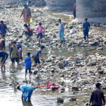 Youths are fishing in the dry canal, taking full advantage of the scarcity of water in the city