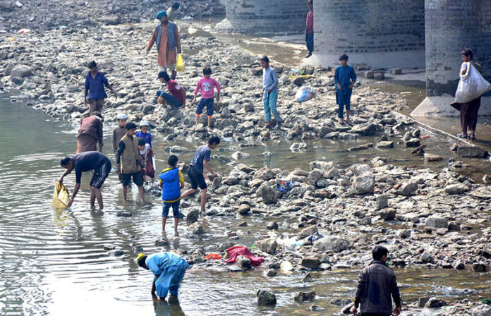 Youths are fishing in the dry canal, taking full advantage of the scarcity of water in the city