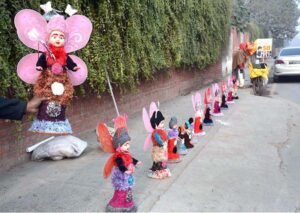 A vendor arranging and displaying toys on footpath to attract the customers.
