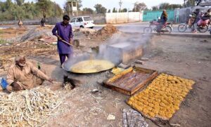 Workers busy in making gurr on his roadside setup.