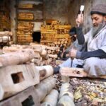 Laborers busy in making parts of traditional bed (charpai) at their workplace in the Dabgari area