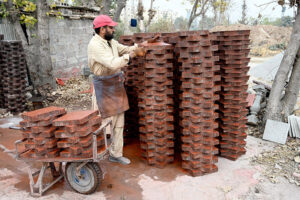 Laborer preparing tuff tiles at his workplace near Pindora area in the City