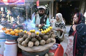 Women buying to enjoy the test of the delicious roasted yams offered by a street hawker in the city's Bara Bazaar.