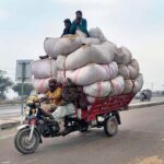 Overloaded delivery tricycles carrying passengers and hay bundles pose a serious accident risk on a highway in the federal capital, urging authorities to take action