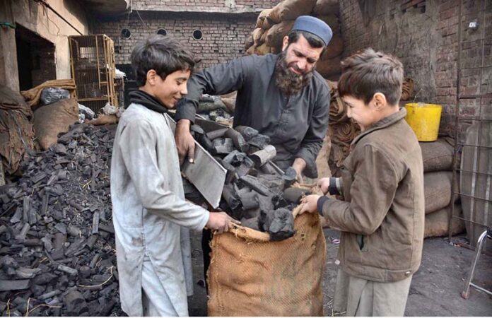 Vendors packing coal in bags for sell at their setup