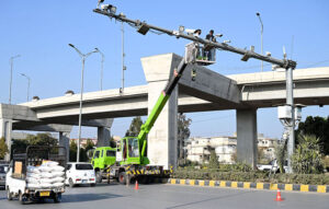 Workers are busy in the maintenance work of CCTV cameras installed at 9th avenue in Federal Capital.