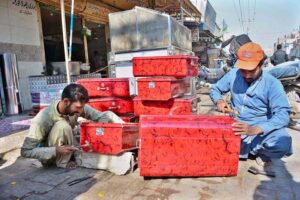 Workers busy preparing the metal iron boxes at their workplace