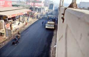 Laborers are busy in the reconstruction of LMQ Road with the help of heavy machinery at Chowk Qaddafi.