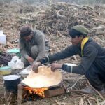 Farmers busy in making bread (roti) after harvesting sugarcane from their field