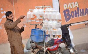 A vendor showcasing beautiful pet fish on his bicycle stand to attract customers along the roadside