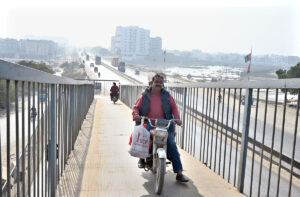 Motorcyclists crossing the Bypass Road using a bridge specifically designed for motorcycles.