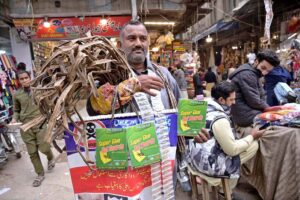 A street vendor selling tooth cleaner herbs and walnut barks (dantasa) in the very busy Urdu Bazaar