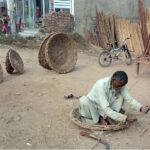 A skilled worker carefully crafts wooden baskets at his workshop