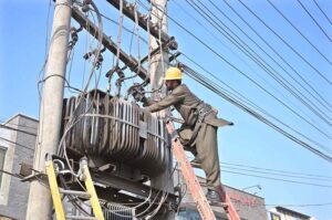 WAPDA staffers busy repairing power transformer on electric pole at Khushab Road