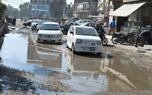 Commuters navigate through pools of accumulated sewerage water at Latifabad Centre, highlighting the need for urgent attention from the concerned authorities