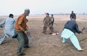 Locals engage in the traditional game of Bandar Killa near the picturesque Chenab River at Head Muhammad Wala.