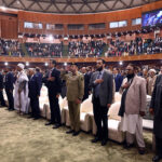 Federal Minister for Information and Broadcasting, Attaullah Tarar along with other participants stands in honor of the national anthem during the International Conference on Girls' Education 2025 at Jinnah Convention Centre