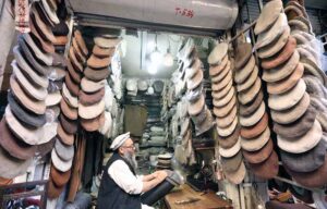 A craftsman meticulously sewing beautiful, warm traditional Chitrali caps at his setup in Jahangirpura.
