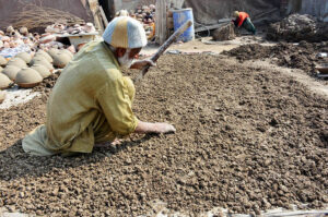 A potter cleans and refines smooth soil to prepare clay, the first step in producing traditional pottery at his workplace on the outskirts of the city.