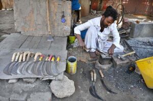 An ironsmith crafting hand sickles (grass cutters) for farmers at his workshop in Tando Hyder