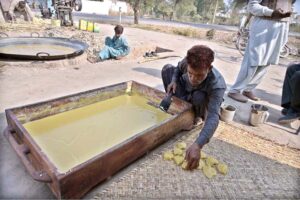 Workers busy in making traditional sweet ‘gurr’ at Khushab Road