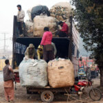 Labourers are busy loading heavy scrap bags on the delivery truck near Rajapur