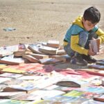 A child selecting old books at a roadside stall in Reagal Chowk