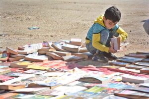 A child selecting old books at a roadside stall in Reagal Chowk
