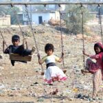 Children delight in the joy of a swing ride at Latifabad, capturing the essence of childhood fun