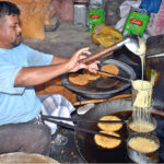 A worker preparing sweet crunch near Gawalmandi Food Street