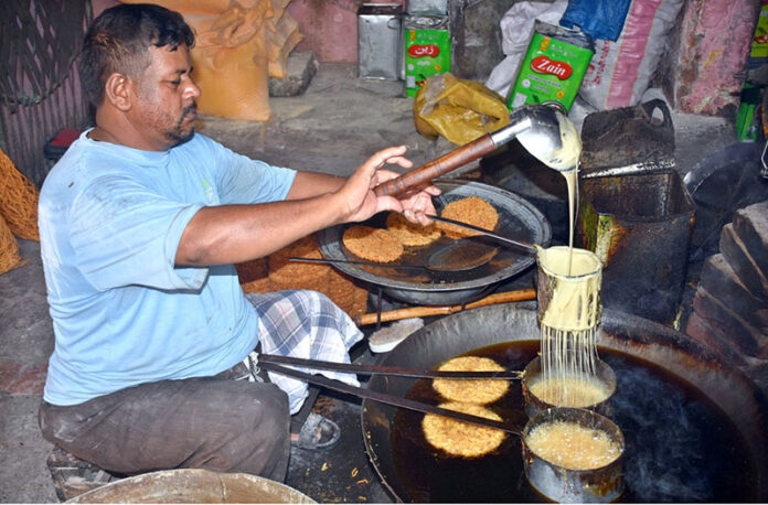 A worker preparing sweet crunch near Gawalmandi Food Street