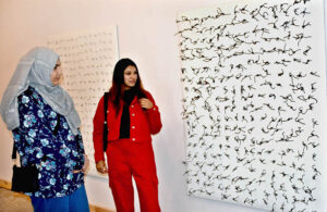 Female students admire the creative art pieces on display at the Master's Degree Show exhibition, held at Shakir Ali Auditorium, National College of Arts in the city .
