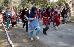 Female enthusiastic candidates participate in a race, aiming to cover one mile in ten minutes as part of the physical test for recruitment in Punjab Police.