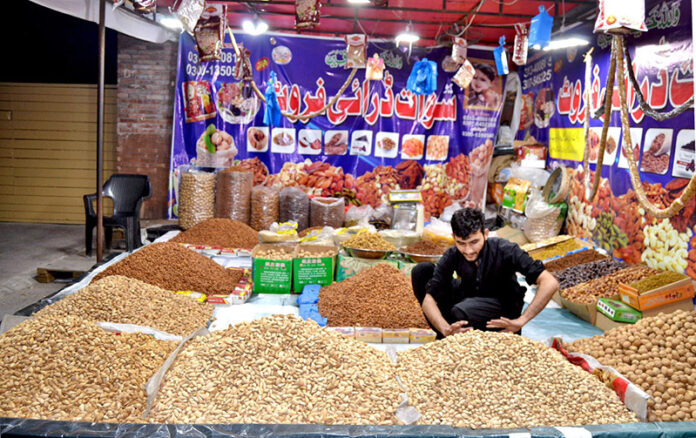 A dry fruit vendor arranging a variety of dry fruits on Sunderdas Road as cold weather sets in