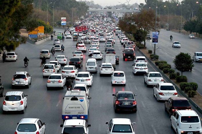 A massive traffic jam clogs the Islamabad Expressway, with seemingly endless queues of cars, buses, and motorcycles stretching as far as the eye can see in the Federal Capital