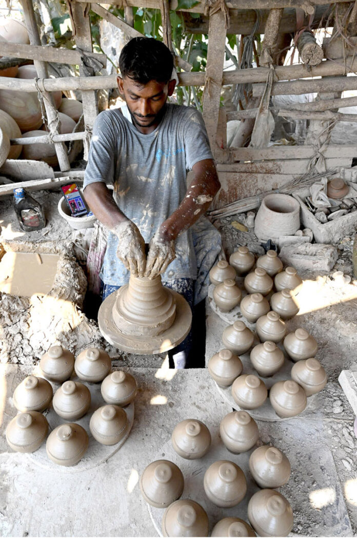 An artisan preparing clay-made stuff at his work place at Kumharpara