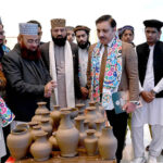 Syed Tauqeer Haider Kazmi, Executive Director of Al-Hammar, appreciates the production of handmade pottery as the organizer briefs him during the Sufism Exhibition at Al-Hammar Hall